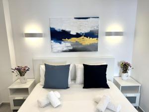 a bedroom with a bed with two pillows at Central Suites Aegina 3 in Egina