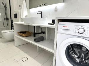 a bathroom with a washing machine and a sink at Central Suites Aegina 3 in Egina