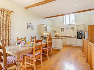 a kitchen and dining room with a wooden table and chairs at 2 Bed in Dulverton oc-threb in East Anstey +21 photos