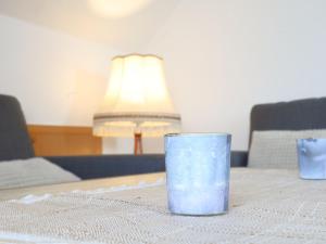 a blue glass sitting on a table with a lamp at Apartment Schonerweg by Interhome in Norddeich
