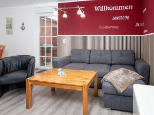 a living room with a couch and a coffee table at Holiday Home Gila by Interhome in Dornumersiel