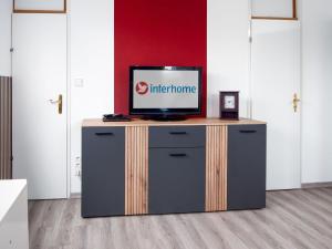 a television on top of a dresser in a room at Holiday Home Gila by Interhome in Dornumersiel +21 photos