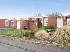 a brick house with a fence in front of it at Holiday Home Gila by Interhome in Dornumersiel