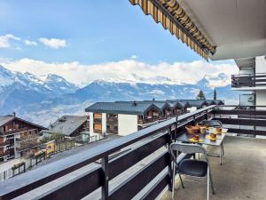 a balcony with a table and chairs and mountains at Apartment App- 20A Ramuge by Interhome in Veysonnaz