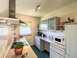 a kitchen with white cabinets and a white microwave at Holiday Home Sonnenbühl by Interhome in Dittishausen