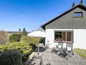 a patio with two chairs and an umbrella at Holiday Home Sonnenbühl by Interhome in Dittishausen