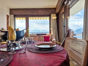 a dining room with a table with a view of the mountains at Apartment App- 20A Ramuge by Interhome in Veysonnaz +15 photos