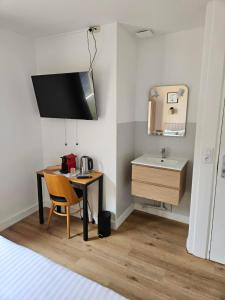 a small room with a table and a sink at Hôtel La Frégate in Fécamp