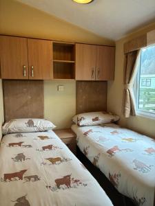 two beds in a small room with cabinets at The Grosvenor 45 in Ardentinny