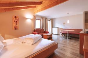 a bedroom with a bed and a living room at Residence Fallrohrhof in Naturno
