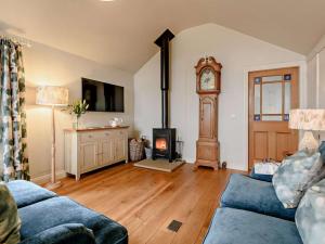 a living room with a fireplace and a grandfather clock at 2 Bed in York oc-91540 in Brandsby