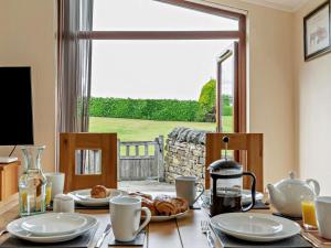 a dining room table with a view of a yard at 2 Bed in Sowerby Bridge oc-90887 in Sowerby Bridge