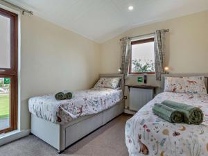 a bedroom with two beds and two windows at 2 Bed in Sowerby Bridge oc-90887 in Sowerby Bridge