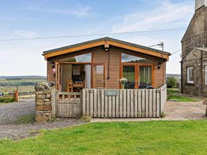 a wooden cabin with a fence next to a building at 2 Bed in Sowerby Bridge oc-90887 in Sowerby Bridge