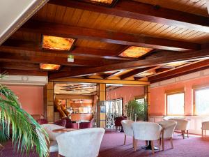 a room with chairs and tables and a ceiling with lights at Hotel Cigoland in Kintzheim
