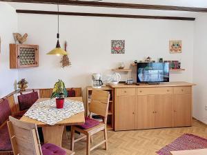 a dining room with a table and a tv at Apartment Am Hohen Bogen-40 by Interhome in Arrach