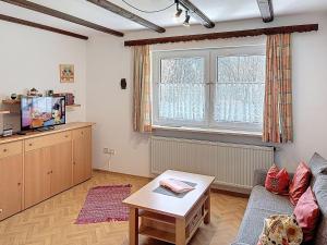 a living room with a couch and a tv at Apartment Am Hohen Bogen-40 by Interhome in Arrach