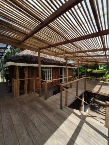 a large wooden deck with a thatched roof at Cabaña LA IGUANA in Capurganá +8 photos