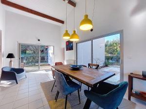 a dining room with a wooden table and chairs at Holiday Home Bernadon by Interhome in Labenne +35 photos