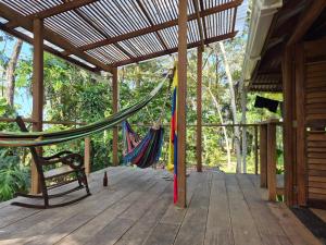 a hammock on a wooden porch with a bench at Cabaña LA IGUANA in Capurganá