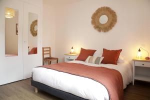 a bedroom with a bed and two tables and a mirror at Paddock Prestige by La Boîte En Plus in Gouvieux