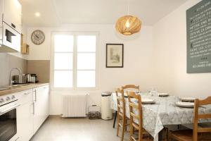 a kitchen with a table with chairs and a window at Paddock Prestige by La Boîte En Plus in Gouvieux
