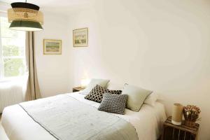 a bedroom with a white bed with pillows on it at Paddock Prestige by La Boîte En Plus in Gouvieux