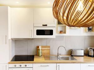 a kitchen with a sink and a microwave at Paddock Prestige by La Boîte En Plus in Gouvieux +15 photos