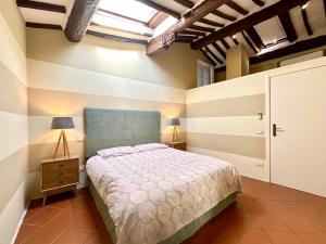a bedroom with a bed and a lamp on a table at Galli Tassi Suite in Lucca