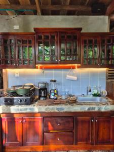 a kitchen with wooden cabinets and a stove and a sink at Cabaña LA IGUANA in Capurganá