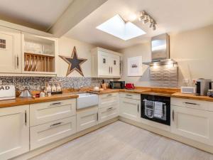 a kitchen with white cabinets and a star on the wall at 2 Bed in Consett oc-90576 in Whittonstall +13 photos