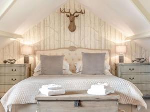 a bedroom with a bed with two dressers and a deer head above it at 2 Bed in Consett oc-90576 in Whittonstall