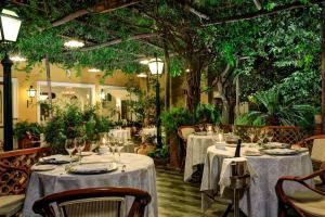 a restaurant with tables with white tablecloths and trees at Grand Hotel de la Ville in Sorrento