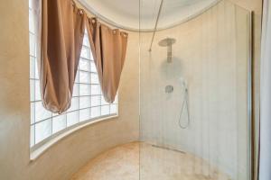 a shower with a glass door in a bathroom at Vista Laguna - Harbour View - Private Jacuzzi in Għajnsielem +45 photos