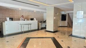 a man standing at a counter in a lobby at Sol Alphaville Hotel & Residence 1004 in Barueri +46 photos