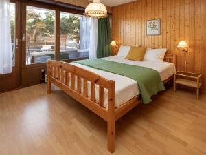 a bedroom with a large bed and a balcony at Apartment Centaure B RI 1 by Interhome in Ovronnaz