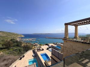 a view of the ocean from a building at Vista Laguna - Harbour View - Private Jacuzzi in Għajnsielem