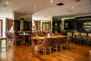 a restaurant with wooden tables and chairs and a bar at Nobile Hotel Premier Hill in Asunción