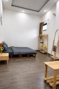 a room with a bed and some wooden tables at La Maison DaLat Home in Ấp Kim Thạch +19 photos
