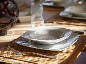 a white bowl and plate on a table at Chalet Orchidée by Interhome in Ovronnaz