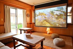 a living room with a large painting on the wall at 南国リゾート Bari Okinawa 連泊宿泊限定価格 in Itoman