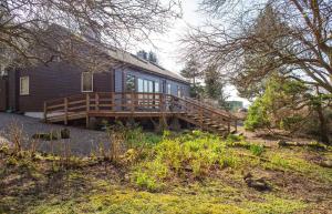 a house with a large wooden deck next to a yard at The Blue Lobster in Drynoch