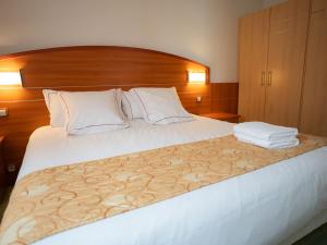 a bedroom with a large bed with a wooden headboard at Hotel Cigoland in Kintzheim +22 photos