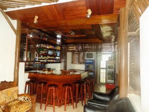 a bar with a bunch of stools in a room at Rhino Motel Mbarara in Mbarara