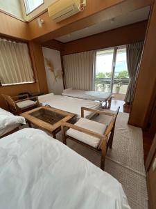 a hotel room with two beds and a window at 南国リゾート Bari Okinawa 連泊宿泊限定価格 in Itoman
