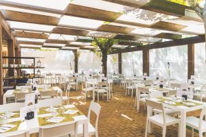 a dining room with white tables and white chairs at Glamping Lido di Spina in Lido di Spina