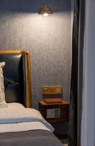 a bedroom with a bed and a table with an alarm clock at HIDDEN BANK: Digger's Dream in Plovdiv