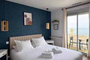 a bedroom with a bed with a view of the ocean at Hôtel La Frégate in Fécamp