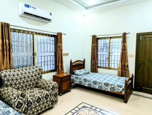 a living room with a couch and a chair at House No 6, Valley Homes in Pothi