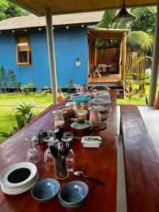 a long wooden table with plates and dishes on it at Vila Saquaira in Marau